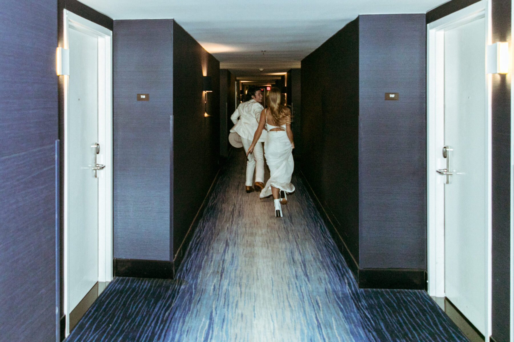 a couple running to the room in a hall