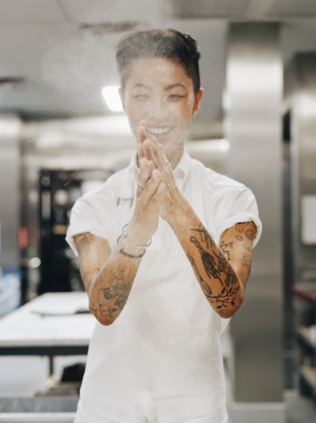 Kristen Kish - a portrait of her clapping with flour in hands