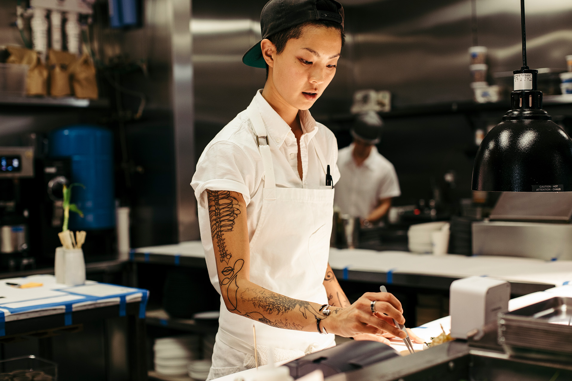 Chef Kristen Kish plating a dish in the kitchen of Arlo Grey