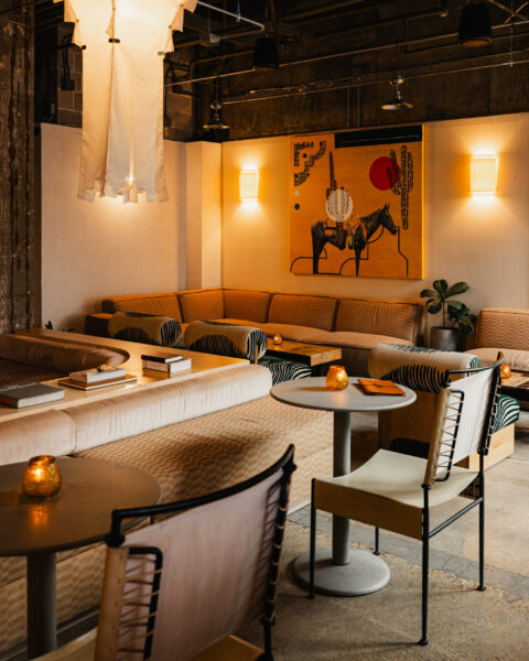 A stylish hotel lounge with warm lighting, cozy seating, and a large Western-themed horse painting on the wall.