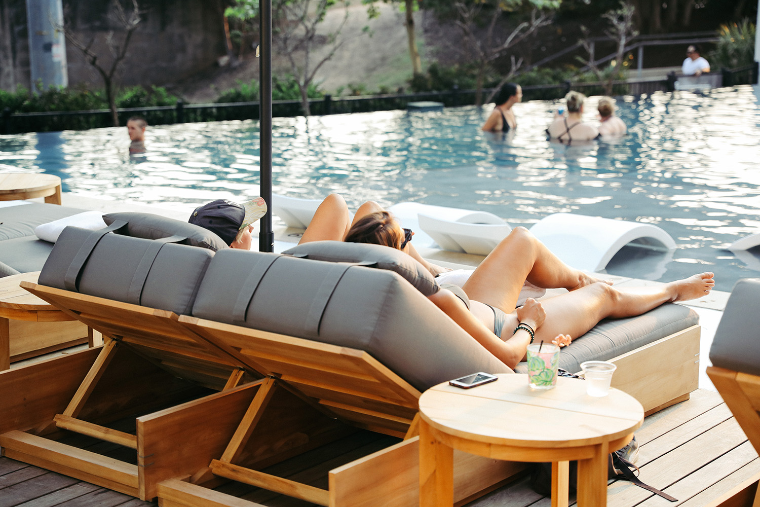 Two people lounging by the pool at the LINE Austin