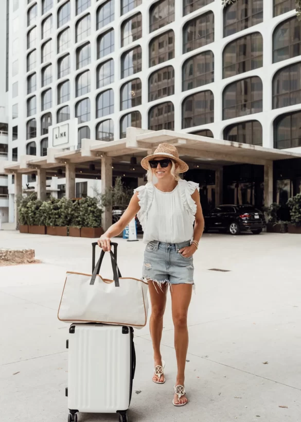 A lady with the luggages in front of the LINE Austin buidling