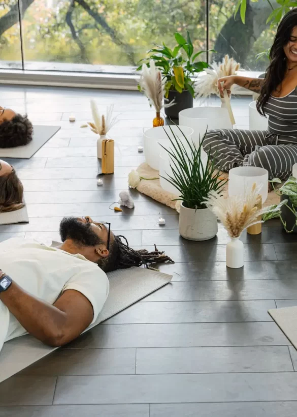 Guided meditation session at The LINE Austin with participants resting on mats in serene, plant-filled room