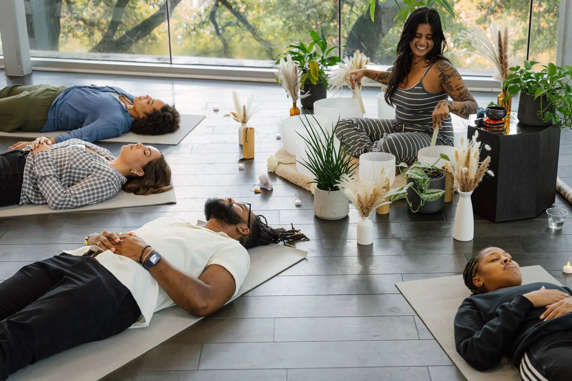 Guided meditation session at The LINE Austin with participants resting on mats in serene, plant-filled room