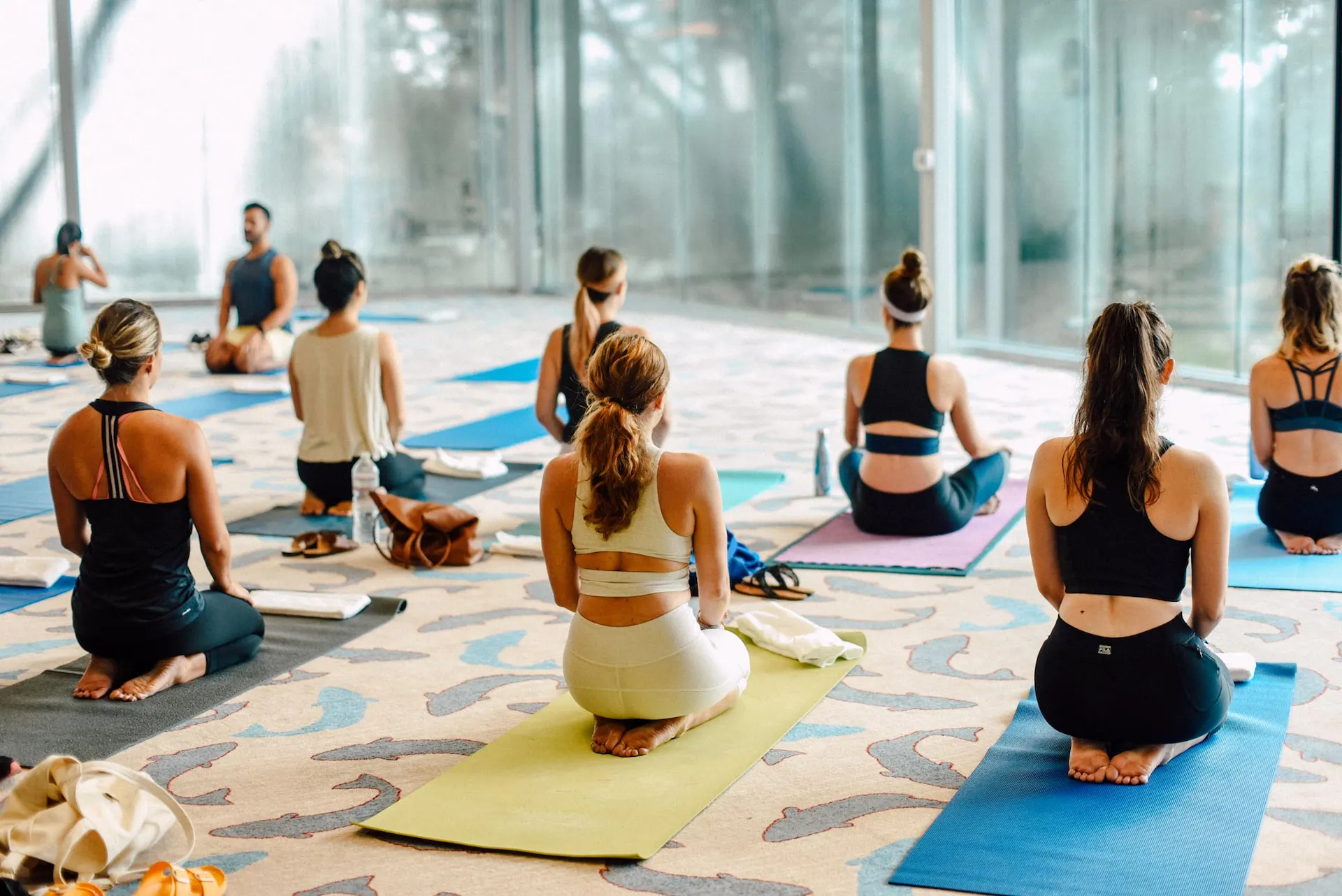 Group yoga session at The LINE Austin with participants kneeling on mats in sunlit, modern room