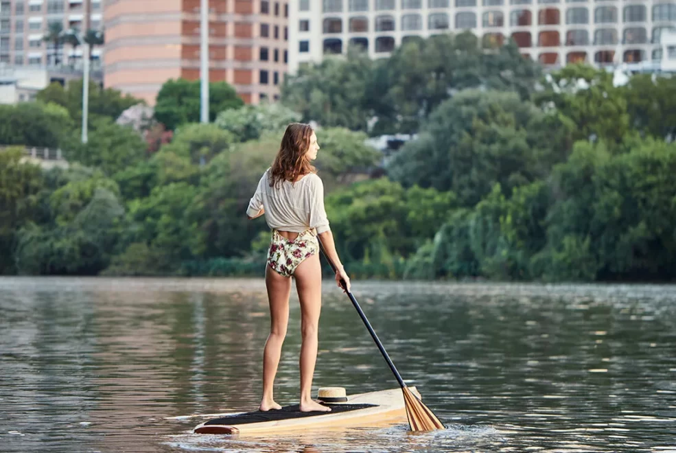 A person stand-up paddle boarding around Lady Bird Lake in Austin, Texas.