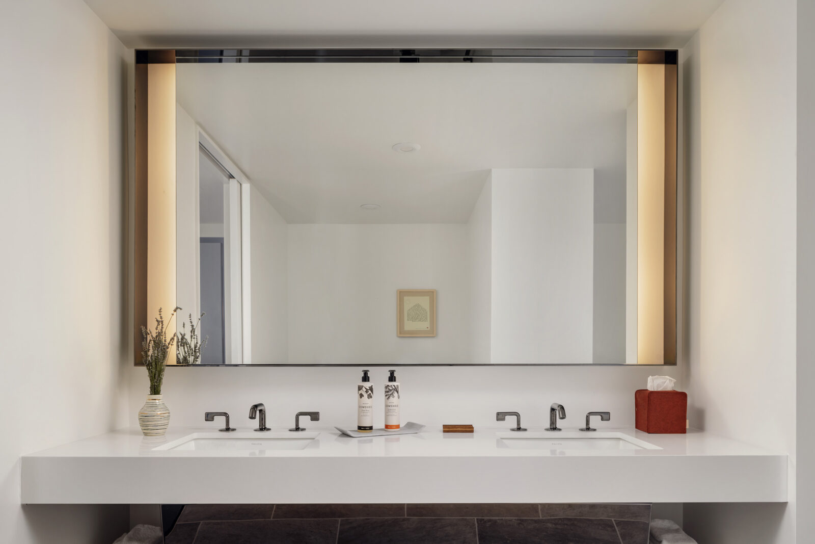 The bathroom has two washbasin sinks with a large wall-fitted mirror just above them.
