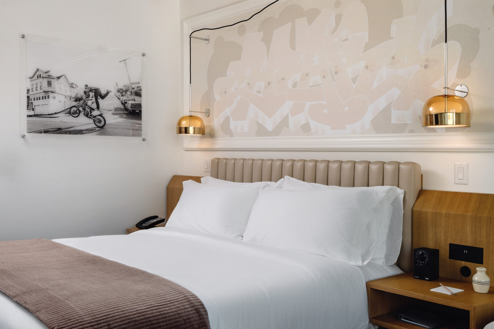 The hotel room contains a king-sized bed with a portrait adorning the left wall.