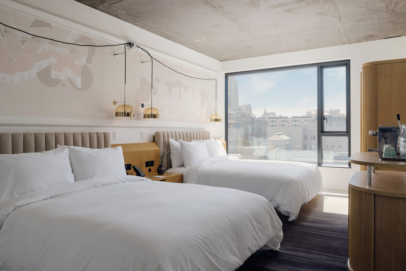 Two king-sized beds positioned near the long glass window, offering a fabulous view of the city.