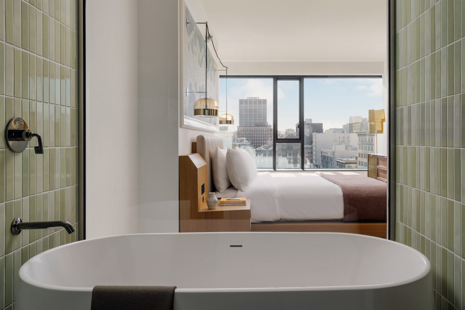 The room offers skyline views along with a soaking tub and a hotel bed.