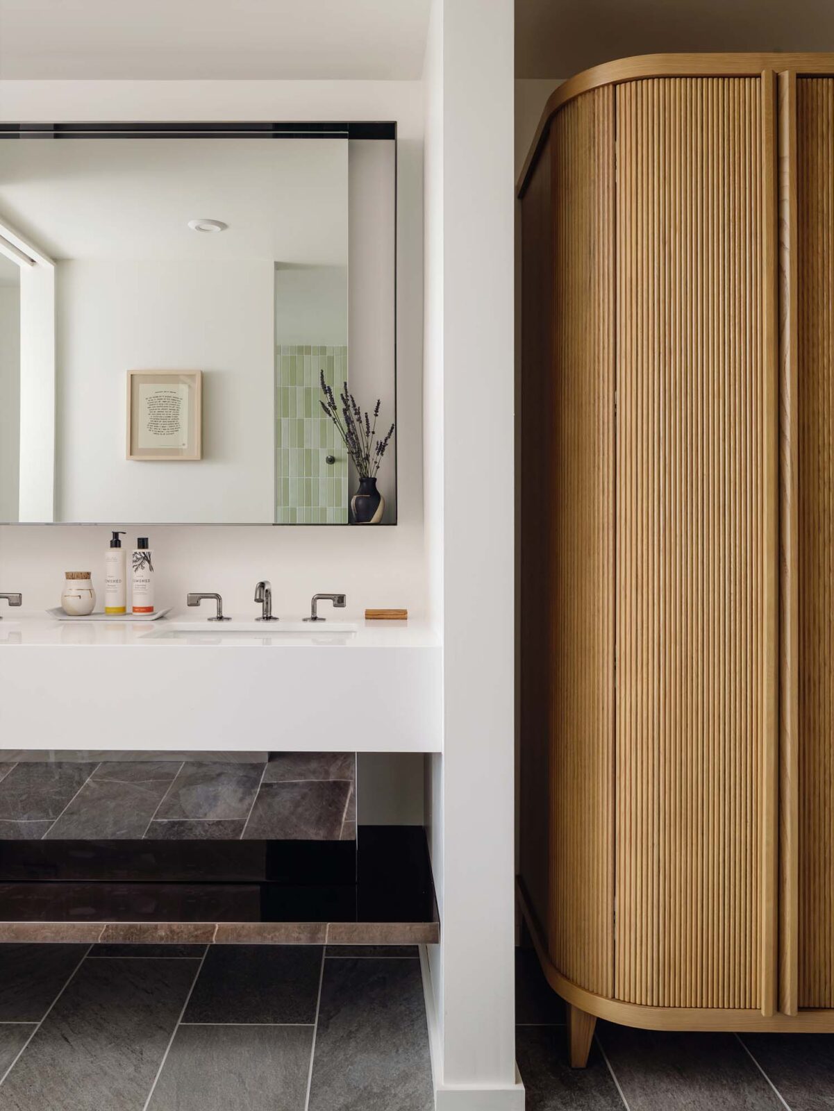 A bathroom sink with a wall-fitted mirror and a wooden touch armoire.