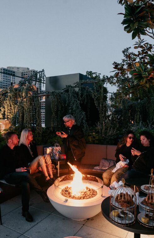 People savor snacks while seated near the rooftop bonfire.