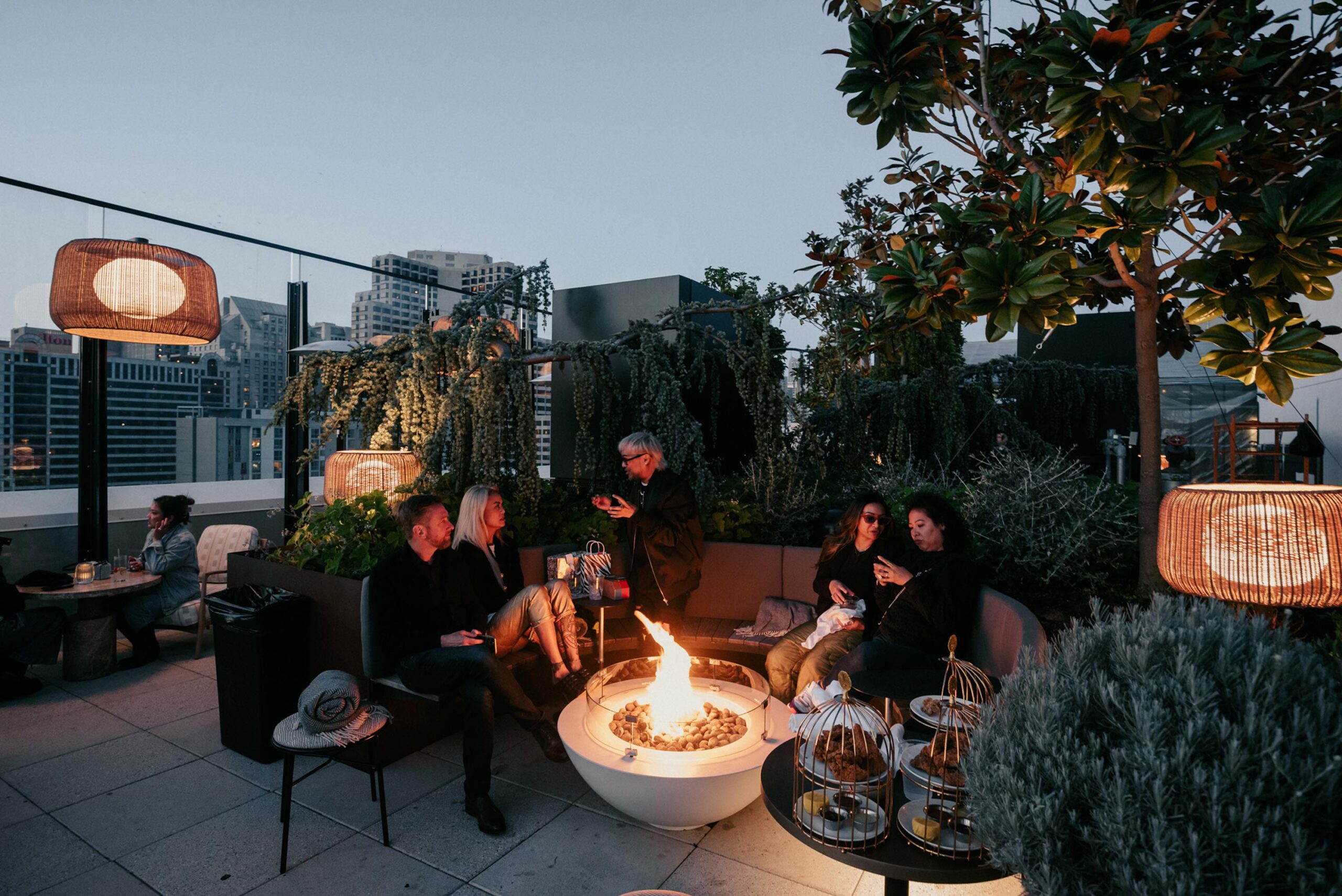 People savor snacks while seated near the rooftop bonfire.