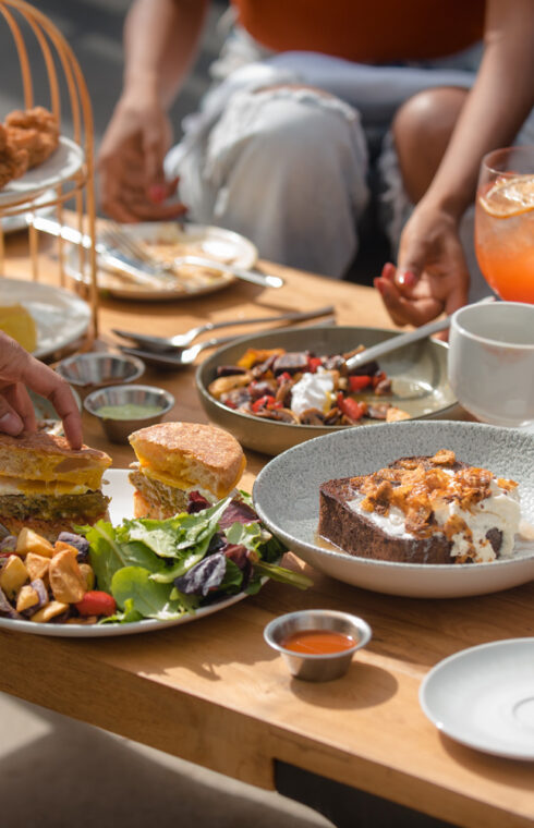 Rooftop brunch dishes and drinks on a table in the sunshine