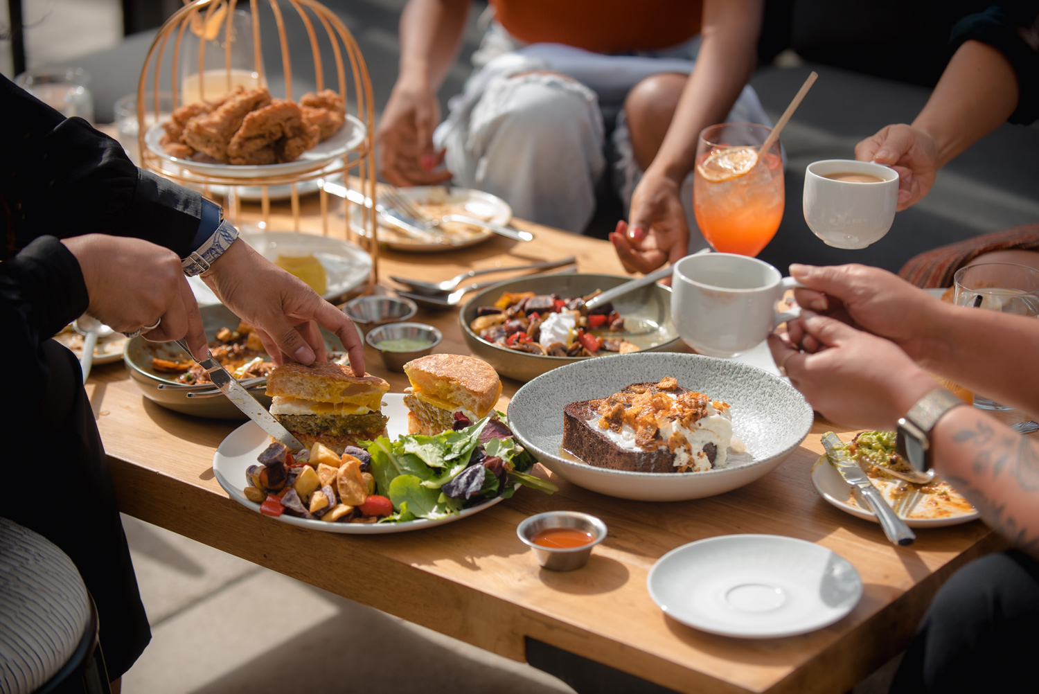 Rooftop brunch dishes and drinks on a table in the sunshine